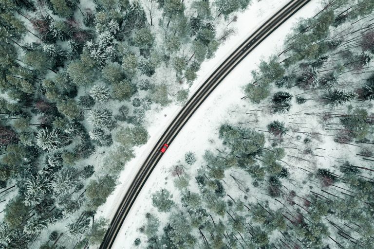 Czerwony samochód na drodze w zimowej scenerii krajobraz z lotu ptaka zdjęcia i filmy z drona Olsztyn