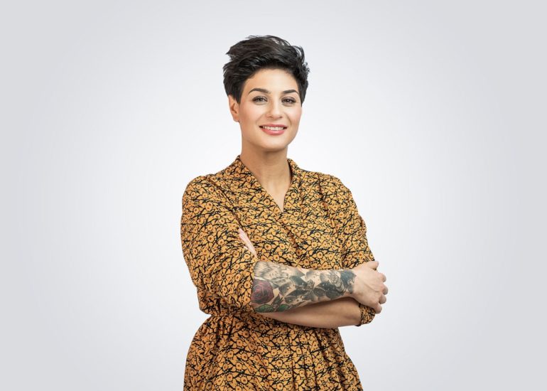 Kobieta z tatuażem na ręce na neutralnym tle - fotografia reklamowa i produktowa Olsztyn