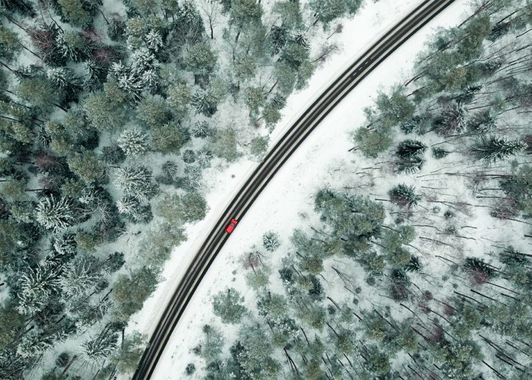 Czerwony samochód na drodze w zimowej scenerii krajobraz z lotu ptaka zdjęcia i filmy z drona Olsztyn