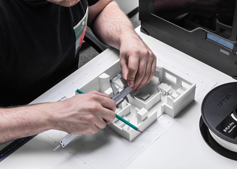 Architekt mierzy model rzutu mieszkania wydrukowanego na drukarce 3d Zortrax