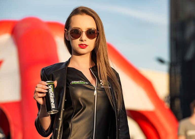 Hostessa pozująca z napojem energetycznym na imprezie motoryzacyjnej w województwie warmińsko-mazurskim