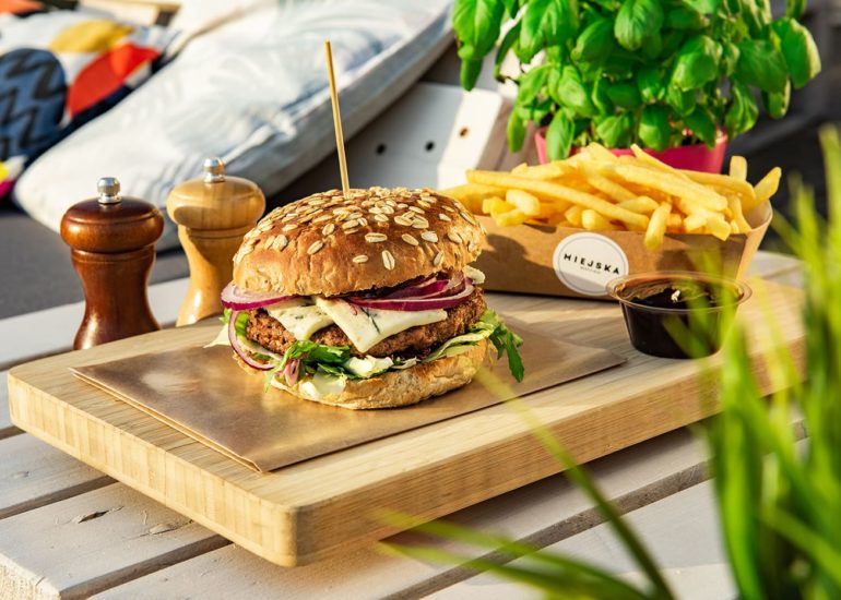 Burger z frytkami na tle kanapy Miejska Beach Bar