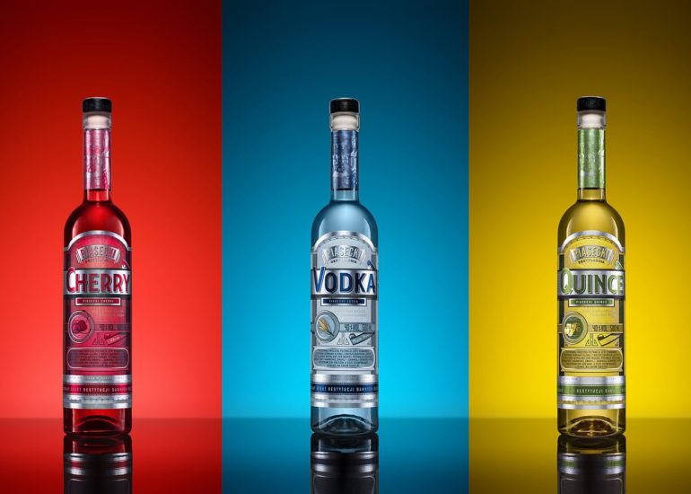 Trzy butelki Piasecki Vodka na trójkolorowym tle fotograf reklamowy Olsztyn