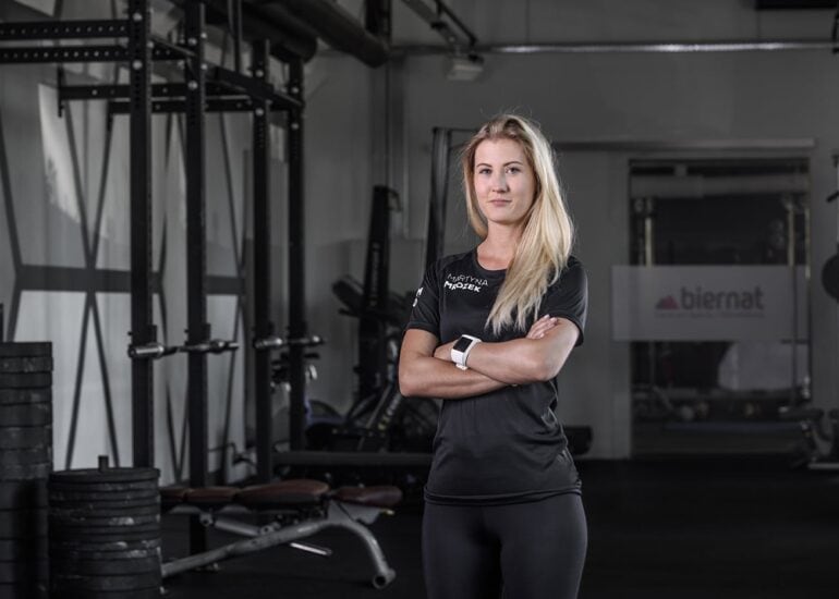 Fizjoterapeutka na tle siłowni w Olsztynie fotografia wizerunkowa