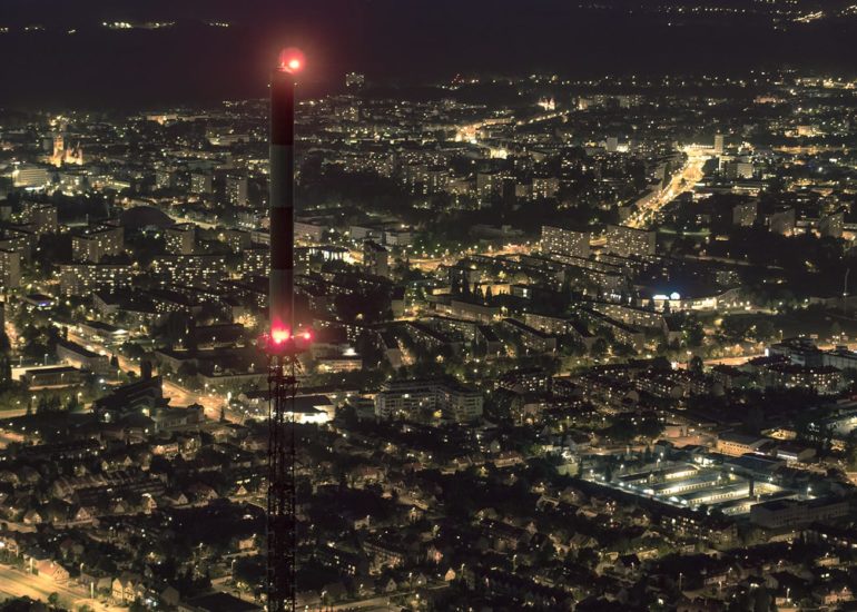 Zdjecie olsztyńskiego masztu radiowo-telewizyjnego na tle nocnych świateł miasta - dron warmińsko-mazurskie